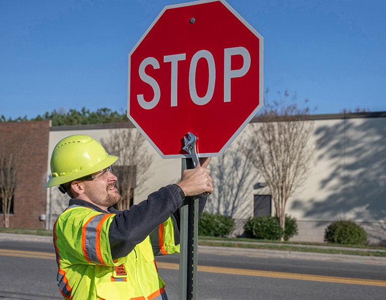 Worker installing stop sign