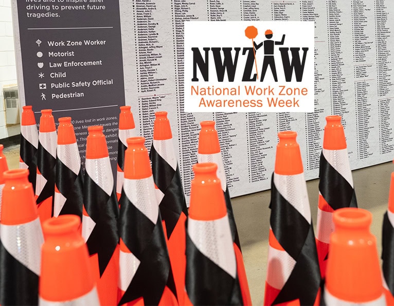 Group of cones with black ribbons in front of the National Work Zone Memorial, with the NWZAW logo